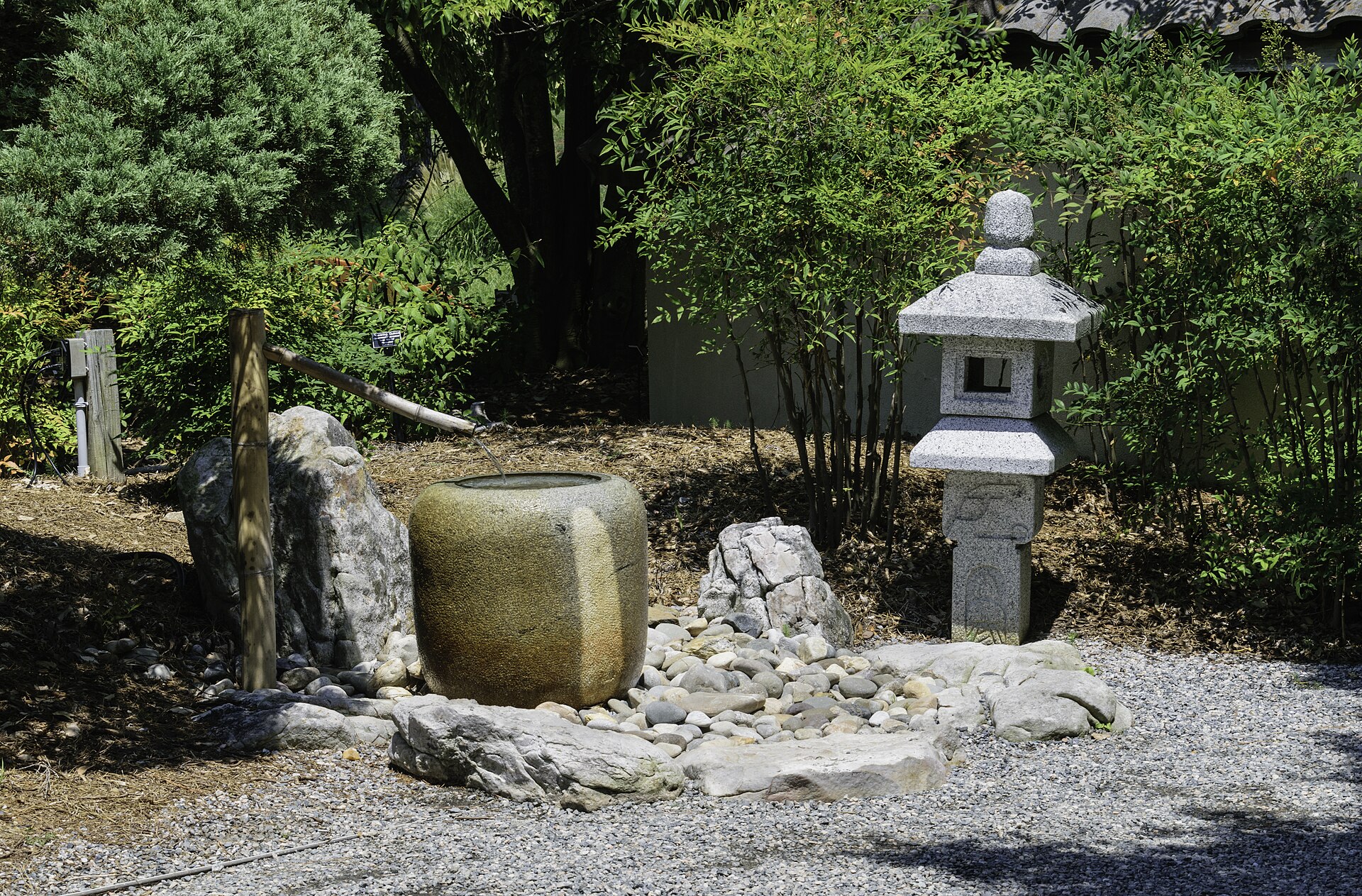 A stone lantern and water basin in a Japanese garden